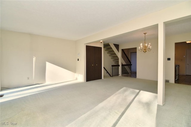 spare room featuring carpet and a chandelier