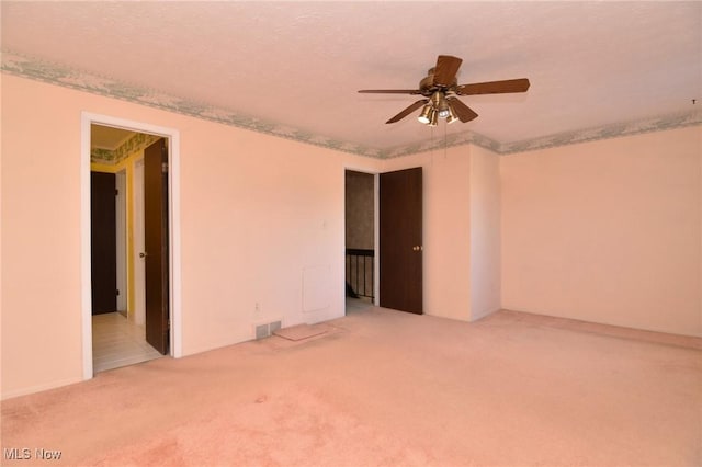 unfurnished room featuring ceiling fan, carpet floors, and a textured ceiling