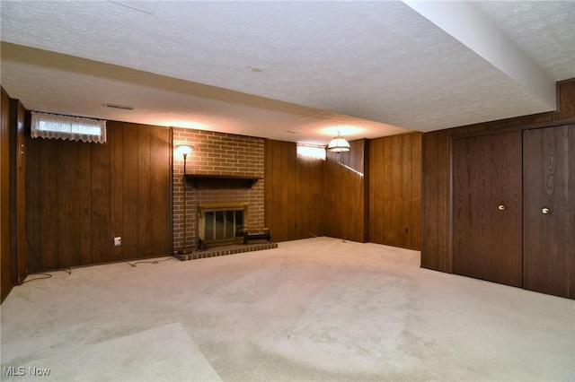 basement featuring carpet, wood walls, and a fireplace