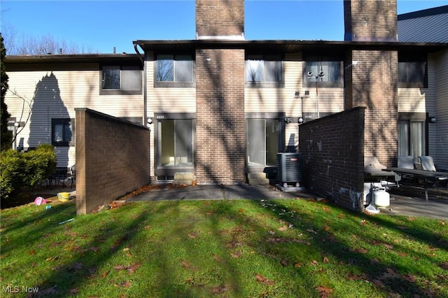 back of property featuring a lawn, central AC unit, and a patio area