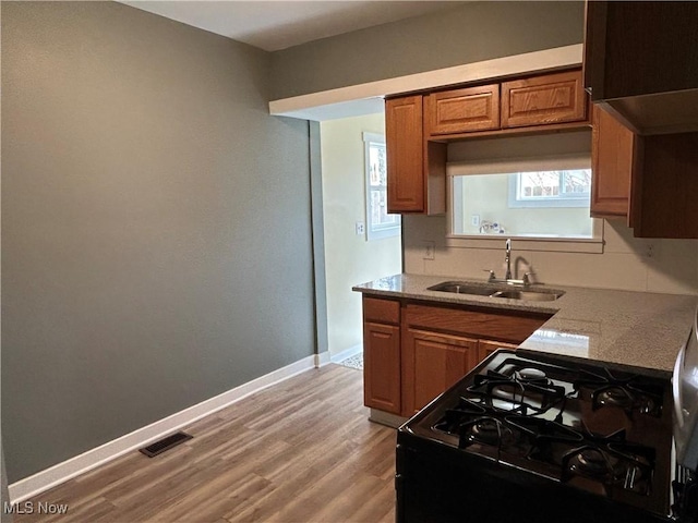 kitchen with gas stove, sink, and light wood-type flooring