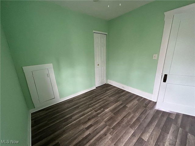 empty room with dark hardwood / wood-style flooring