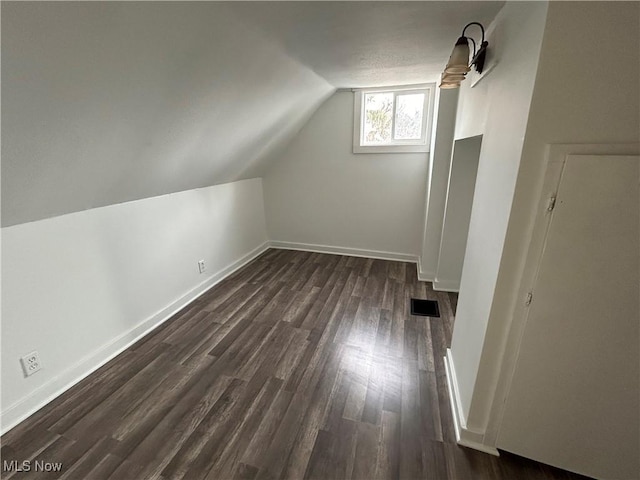 bonus room with lofted ceiling and dark hardwood / wood-style floors