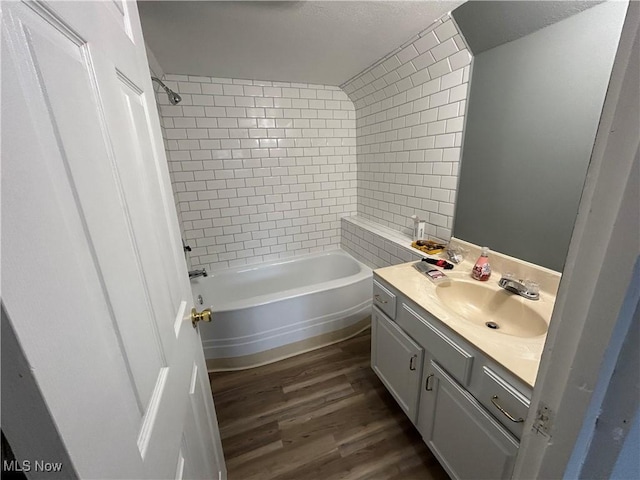 bathroom with tiled shower / bath, vanity, and wood-type flooring