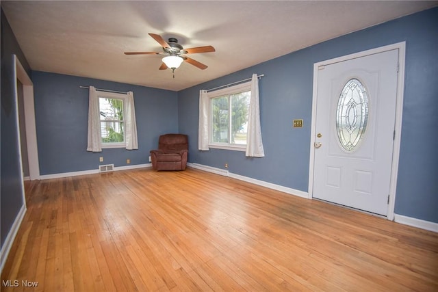 entrance foyer with baseboard heating, ceiling fan, and light wood-type flooring