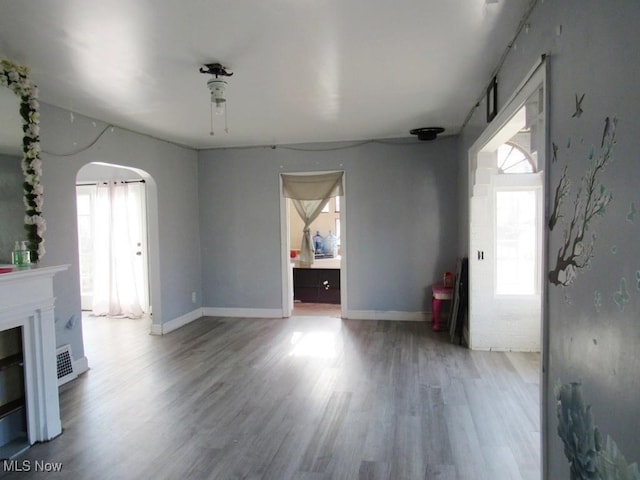 unfurnished living room featuring a fireplace and wood-type flooring