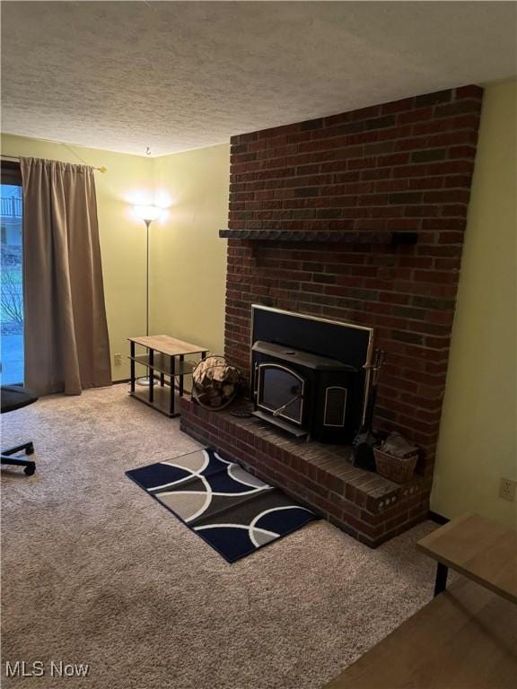 carpeted living room featuring a wood stove and a textured ceiling