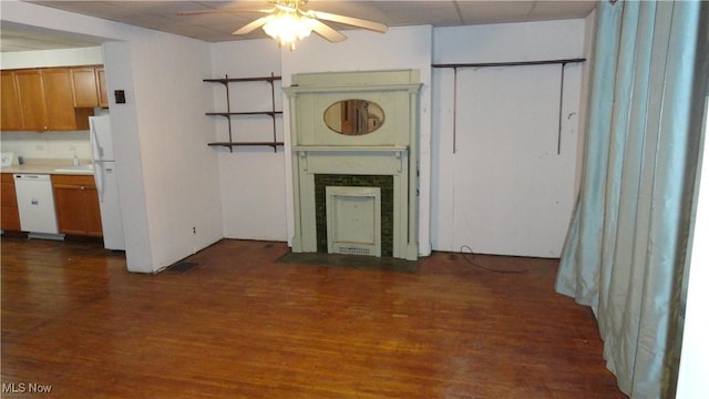 unfurnished living room with ceiling fan, a high end fireplace, and dark wood-type flooring