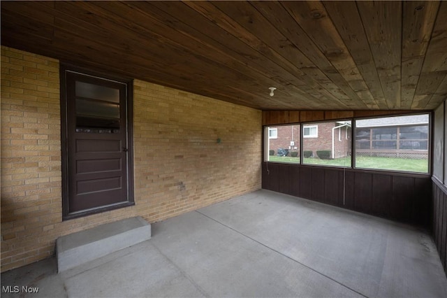 unfurnished sunroom featuring lofted ceiling and wood ceiling