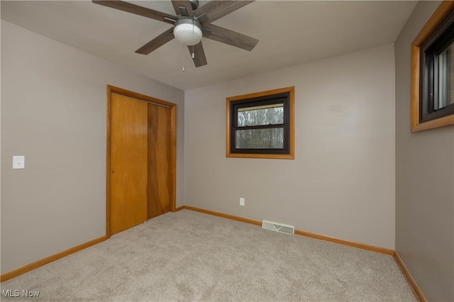 unfurnished bedroom featuring ceiling fan, carpet floors, and a closet