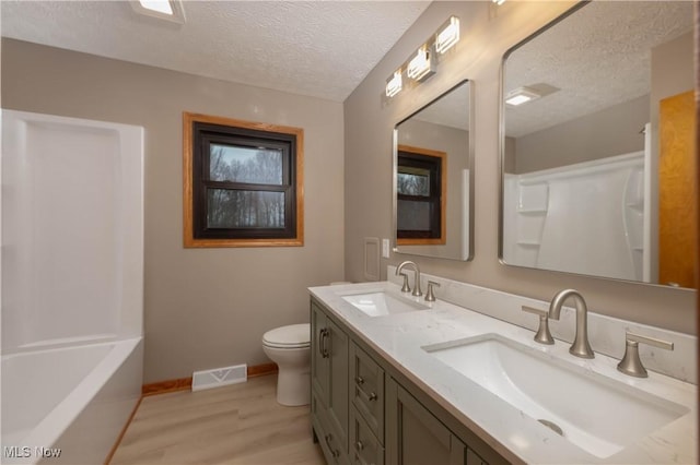 bathroom with toilet, vanity, a textured ceiling, and hardwood / wood-style flooring