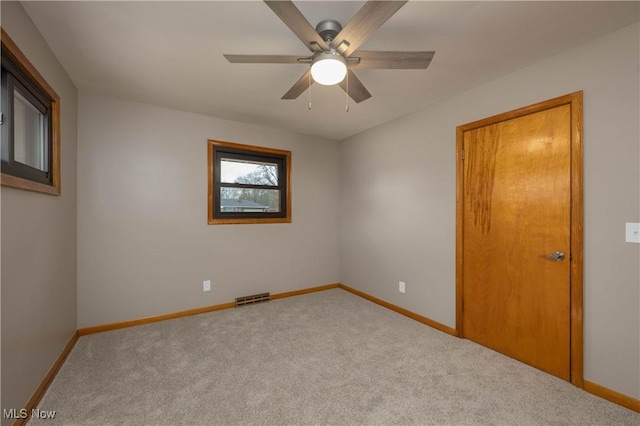 spare room featuring light carpet and ceiling fan