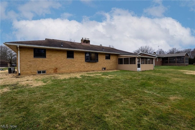 rear view of property with a sunroom, cooling unit, and a yard