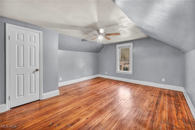 bonus room with a textured ceiling, ceiling fan, light hardwood / wood-style floors, and lofted ceiling