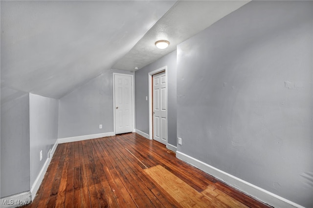 bonus room with hardwood / wood-style floors and vaulted ceiling