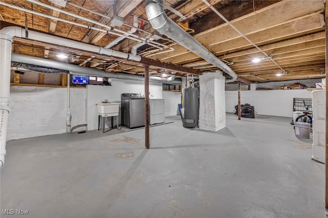 basement with washing machine and dryer, sink, and water heater