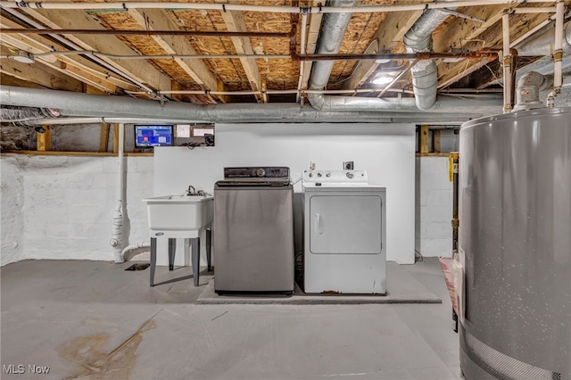 basement featuring separate washer and dryer, sink, and water heater