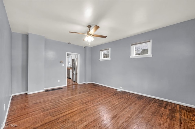 empty room with hardwood / wood-style floors and ceiling fan