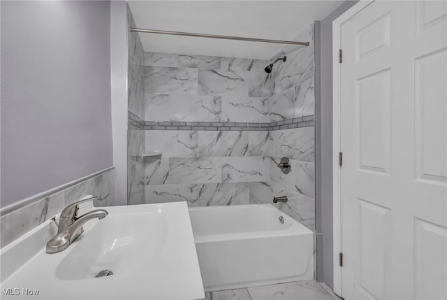 bathroom featuring tiled shower / bath and sink