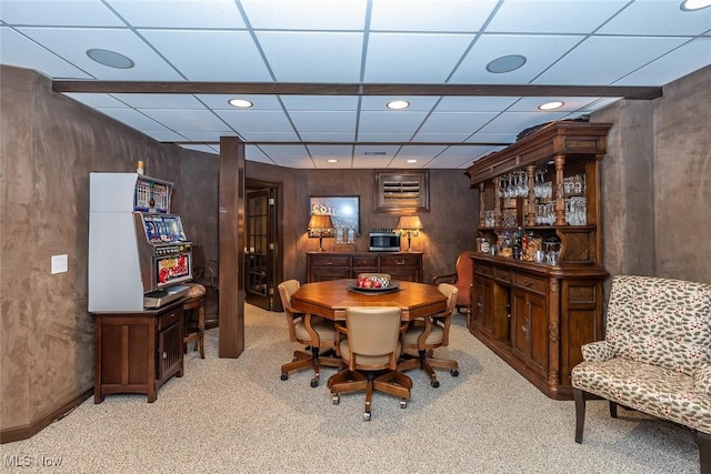 carpeted dining space with a drop ceiling