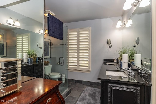 bathroom with a chandelier, vanity, toilet, and walk in shower