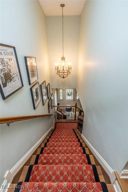 staircase featuring a chandelier