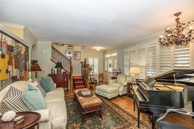 living room featuring hardwood / wood-style floors, an inviting chandelier, and ornamental molding