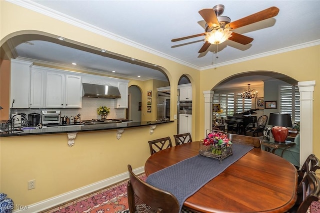 dining area with ceiling fan with notable chandelier, crown molding, and sink