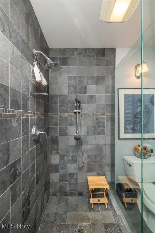 bathroom with toilet and tiled shower