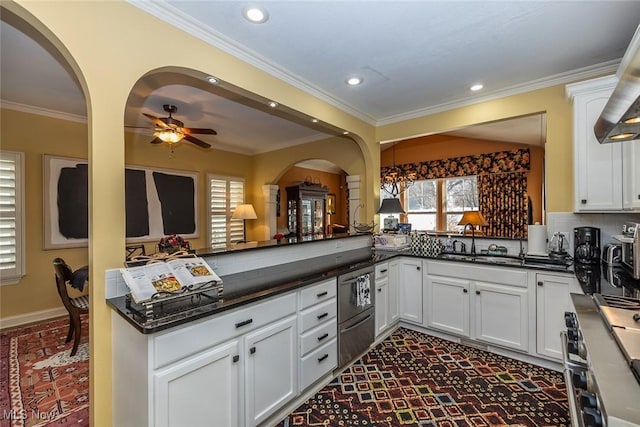 kitchen with kitchen peninsula, a healthy amount of sunlight, white cabinetry, and sink