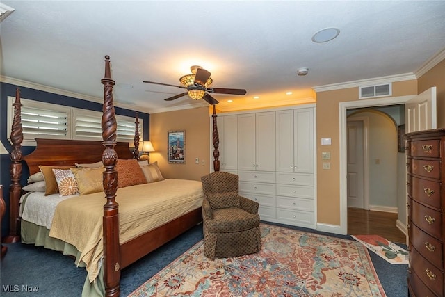 bedroom featuring dark colored carpet, a closet, ceiling fan, and crown molding