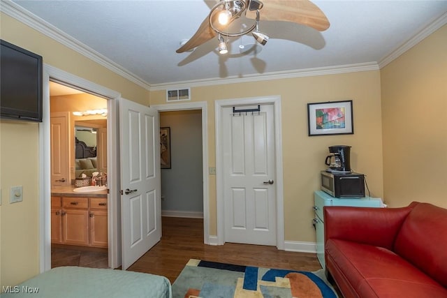 bedroom with ceiling fan, sink, dark hardwood / wood-style floors, and ornamental molding