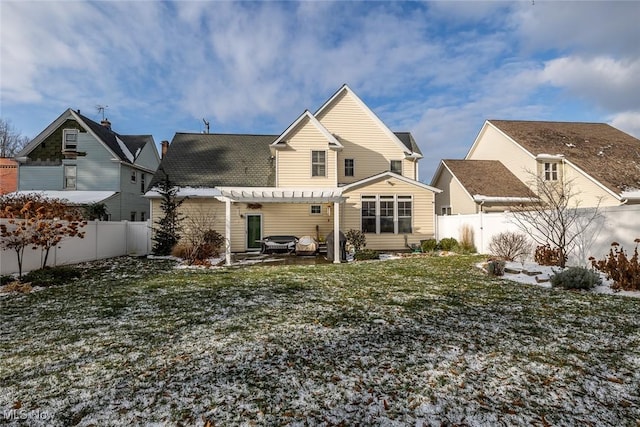 rear view of property featuring a pergola and a yard