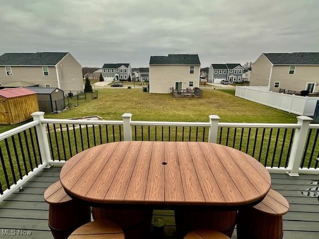 deck with a storage unit and a lawn