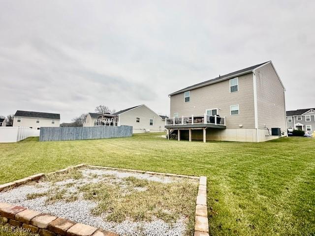 back of house with a lawn, central AC unit, and a wooden deck