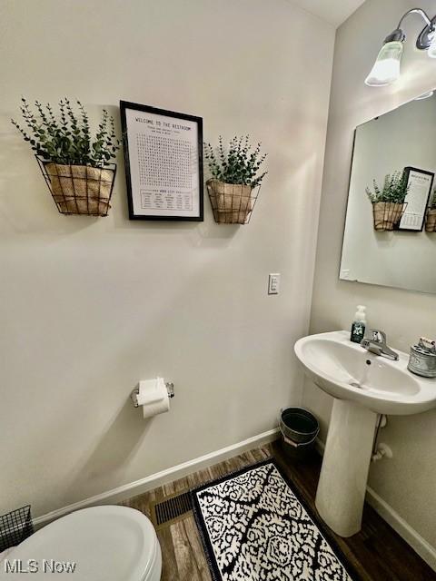 bathroom featuring hardwood / wood-style floors and toilet