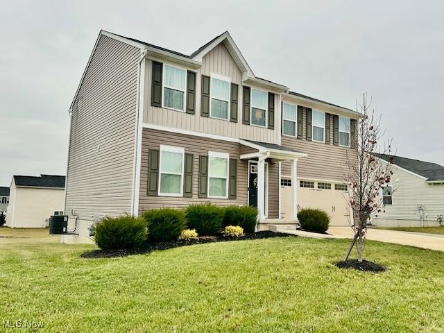 view of front of property featuring a front lawn, a garage, and cooling unit