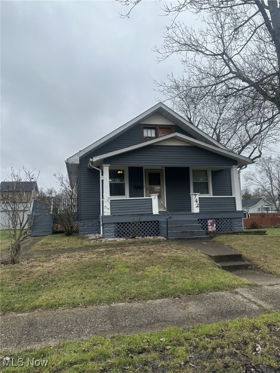 bungalow-style house featuring a porch and a front lawn