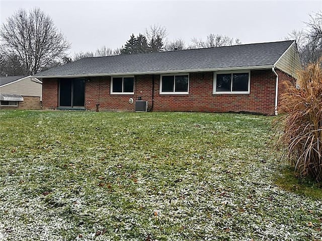 rear view of house with a lawn and cooling unit