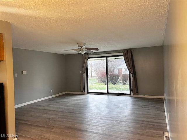 spare room featuring ceiling fan, dark hardwood / wood-style flooring, and a textured ceiling