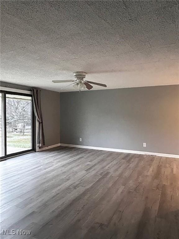 spare room featuring wood-type flooring, a textured ceiling, and ceiling fan