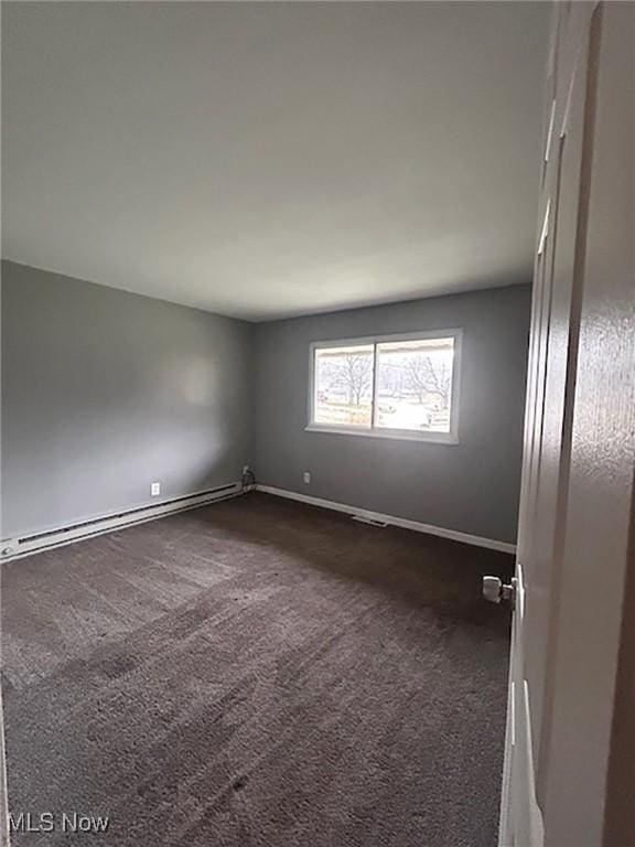 carpeted empty room with a baseboard radiator