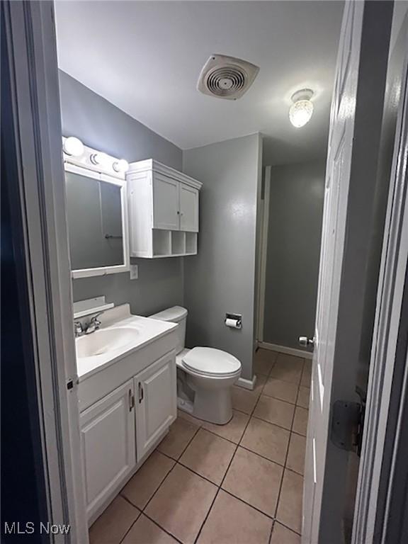 bathroom featuring tile patterned flooring, vanity, and toilet