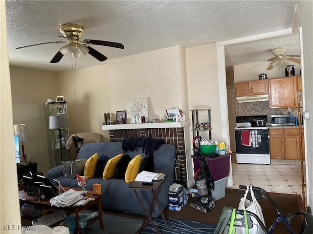 living area with a textured ceiling and ceiling fan