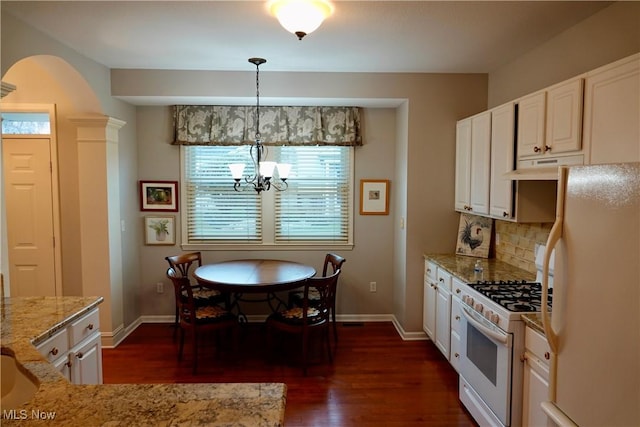 kitchen with light stone countertops, dark hardwood / wood-style flooring, a notable chandelier, decorative light fixtures, and white appliances