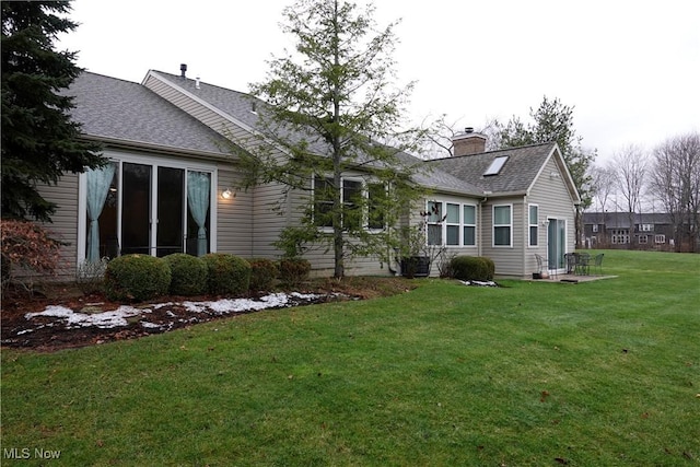 rear view of house featuring a yard