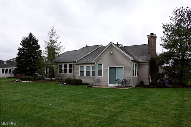 rear view of property with a yard and a patio