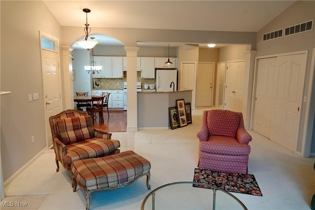 living room featuring vaulted ceiling and a notable chandelier