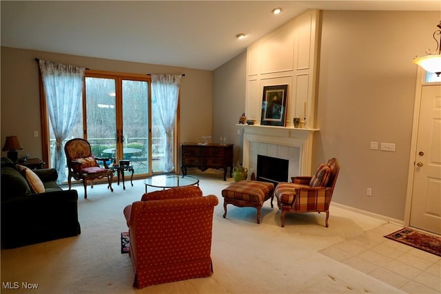 carpeted living room with a tile fireplace and lofted ceiling