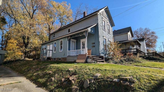 view of front of house featuring covered porch and a front lawn